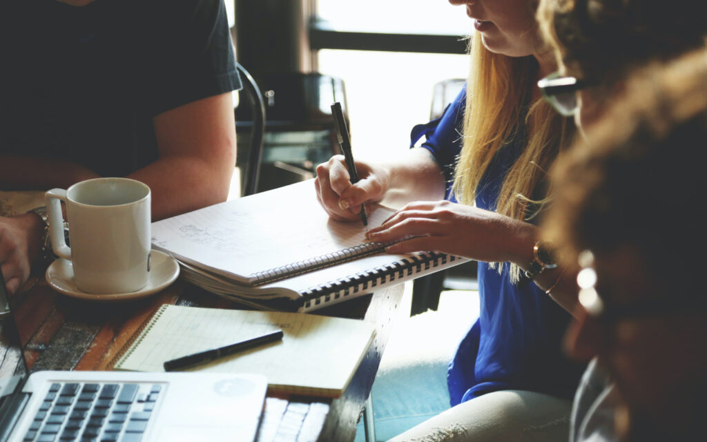 Eine Frau notiert etwas auf einem Block.