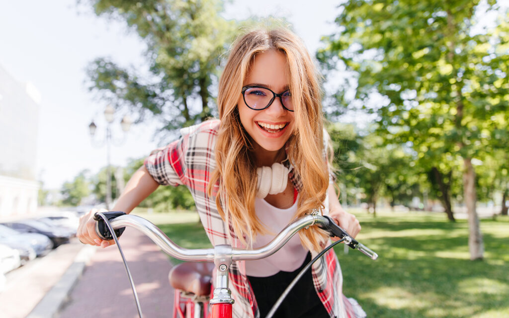 Jugendliche auf einem Fahrrad schaut lachend in die Kamera