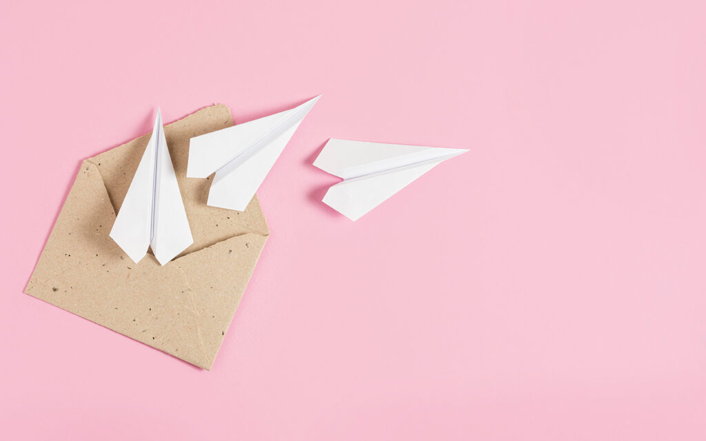 Papierflieger fliegen aus einem ge&ouml;ffneten Kuvert