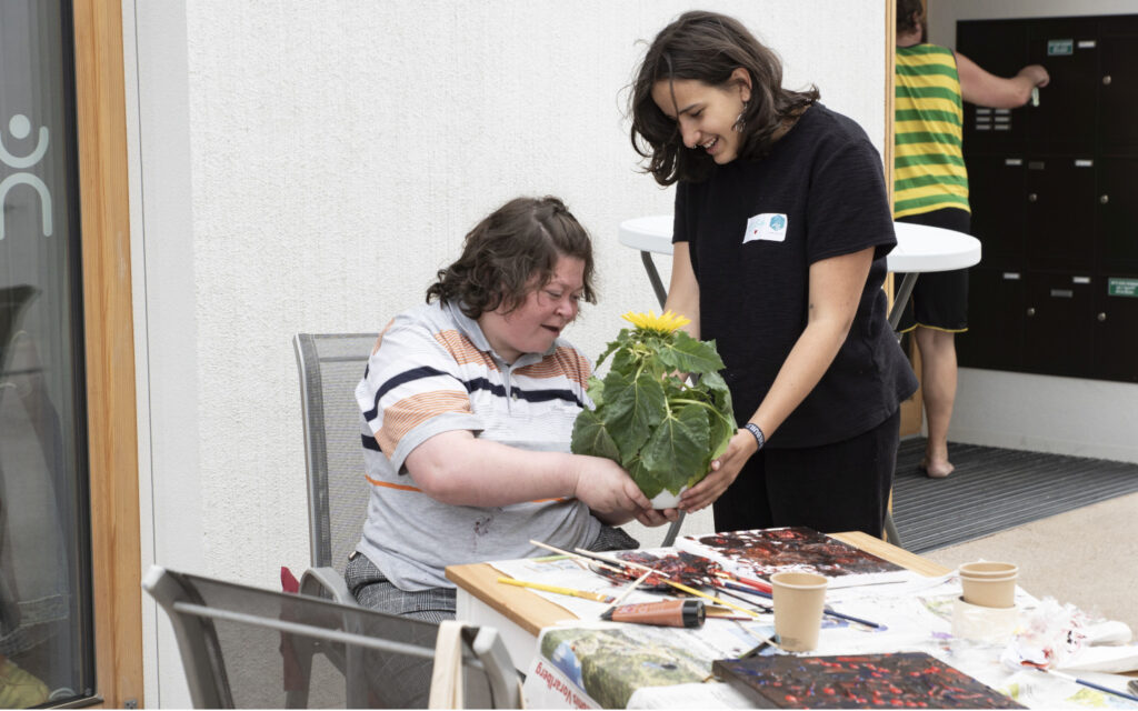Zwei junge Frauen arbeiten gemeinsam an einem Kunstprojekt.