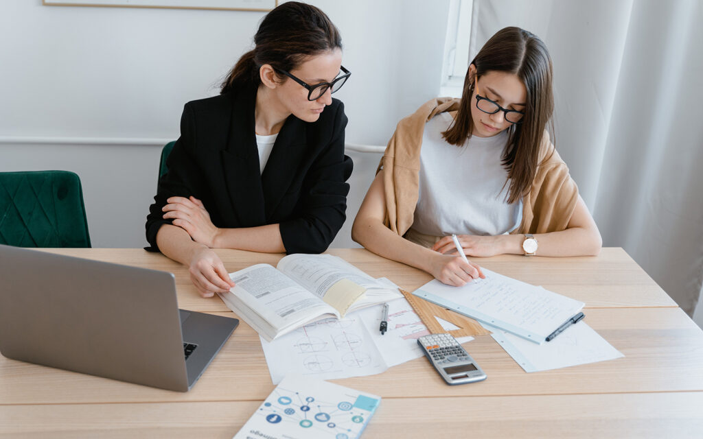 Eine Nachhilfelehrerin gibt einer Schülerin Nachhilfe in Mathematik