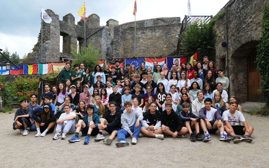 Eine gro&szlig;e Gruppe internationaler Jugendlicher posiert vor der Kamer