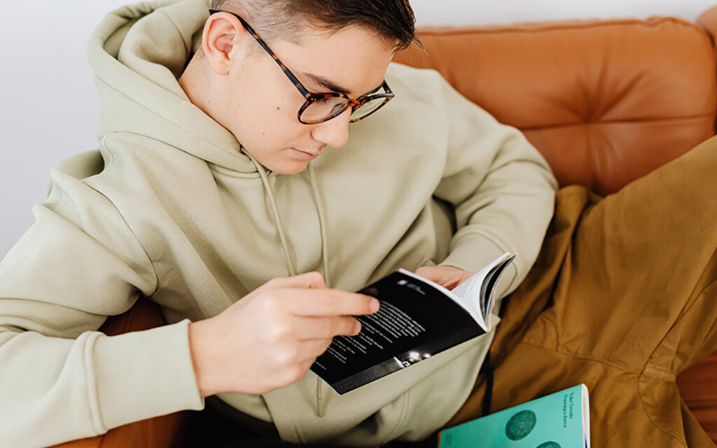 Ein Junge liest auf der Couch ein Buch