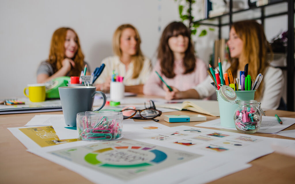 Junge Frauen arbeiten am Tisch an einem Projekt