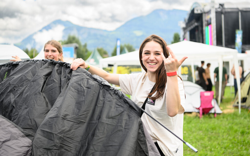 M&auml;dchen stellt auf dem Festivalgel&auml;nde ihr Zelt auf
