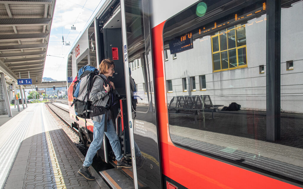 M&auml;dchen steigt mit einem gro&szlig;en Rucksack in einen Zug