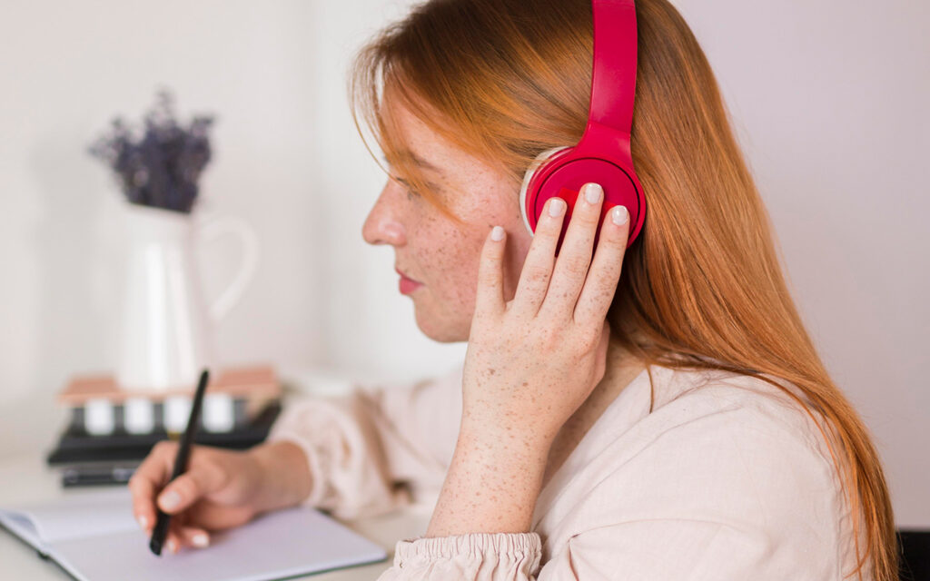 Mädchen hört sich den Lernstoff über den Kopfhörer an