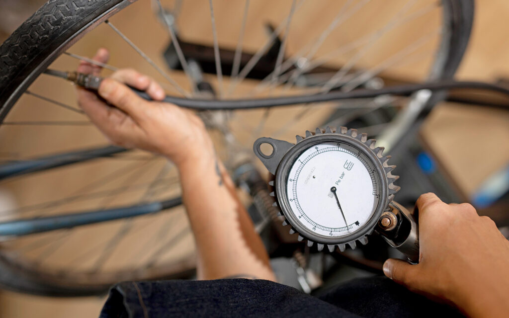 Der Schlauch eines Rades wird an einer Pumpstation aufgeladen