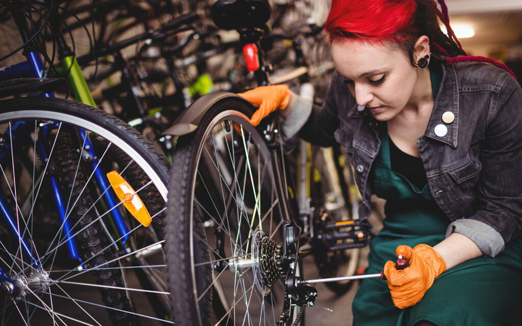 Junge Frau repariert ein Fahrrad