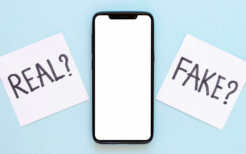 Das Bild zeigt den leeren Bildschirm eines Smartphones und daneben poppen Fragen auf wie "Real?" und "Fake?"