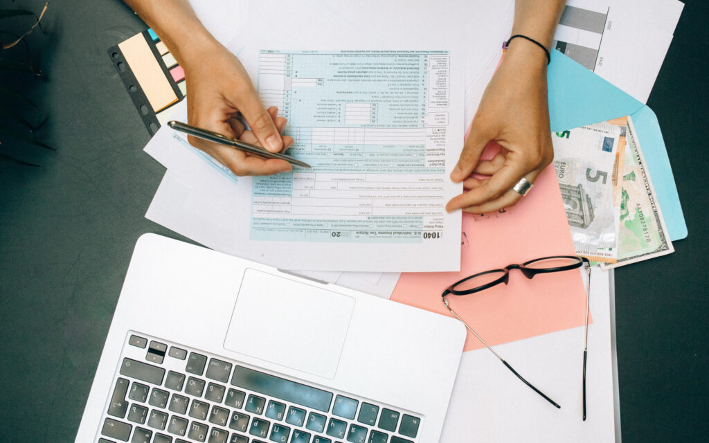 Eine Person sitzt an einem Tisch und füllt ein Formular aus.