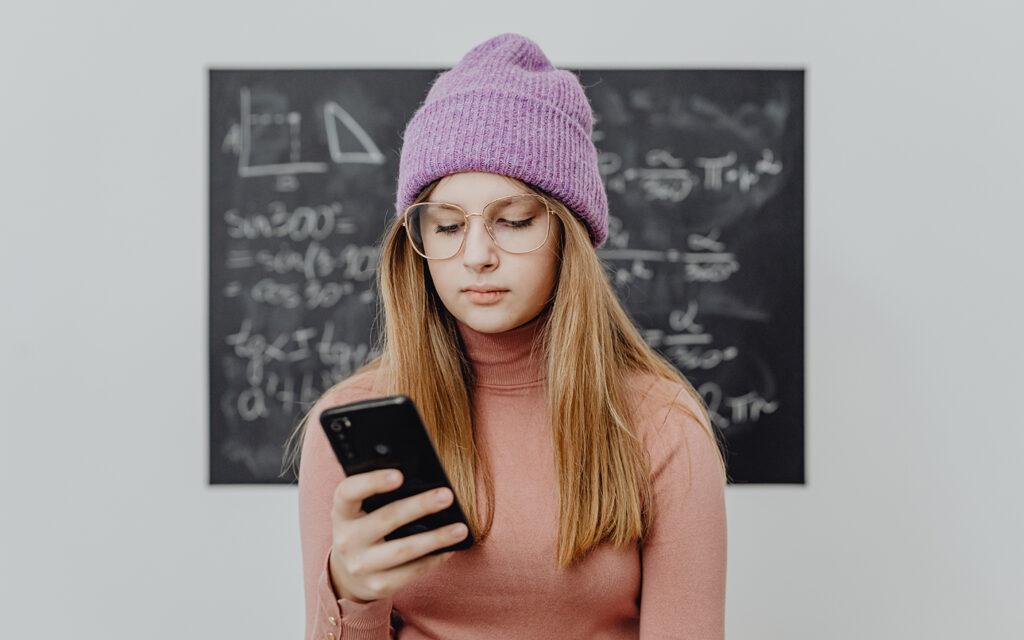 Mädchen schaut kritisch auf ihr Smartphone
