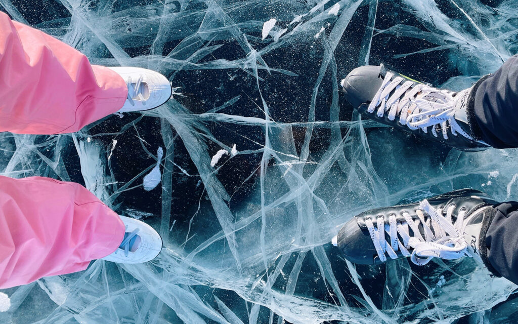 Man sieht die Eislaufschuhe von einem M&auml;dchen und einem Jungen - Kamera von oben herab