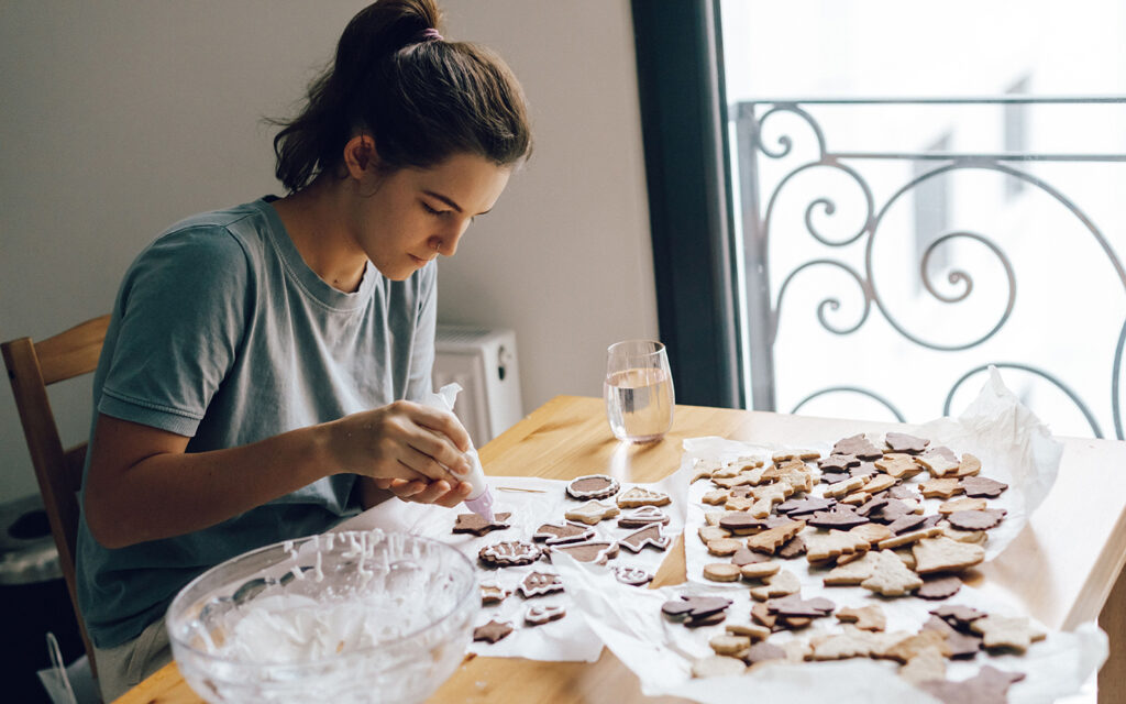 Junge Frau verziert selbstgebackene Kekse