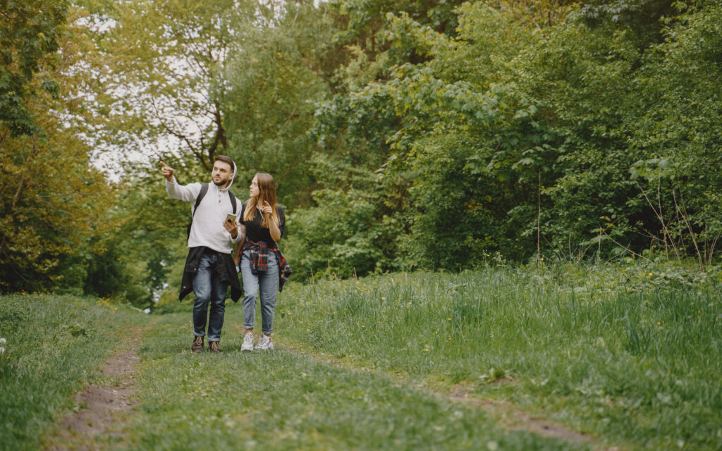 Ein junge Mann und eine junge Frau spazieren durch den Wald.