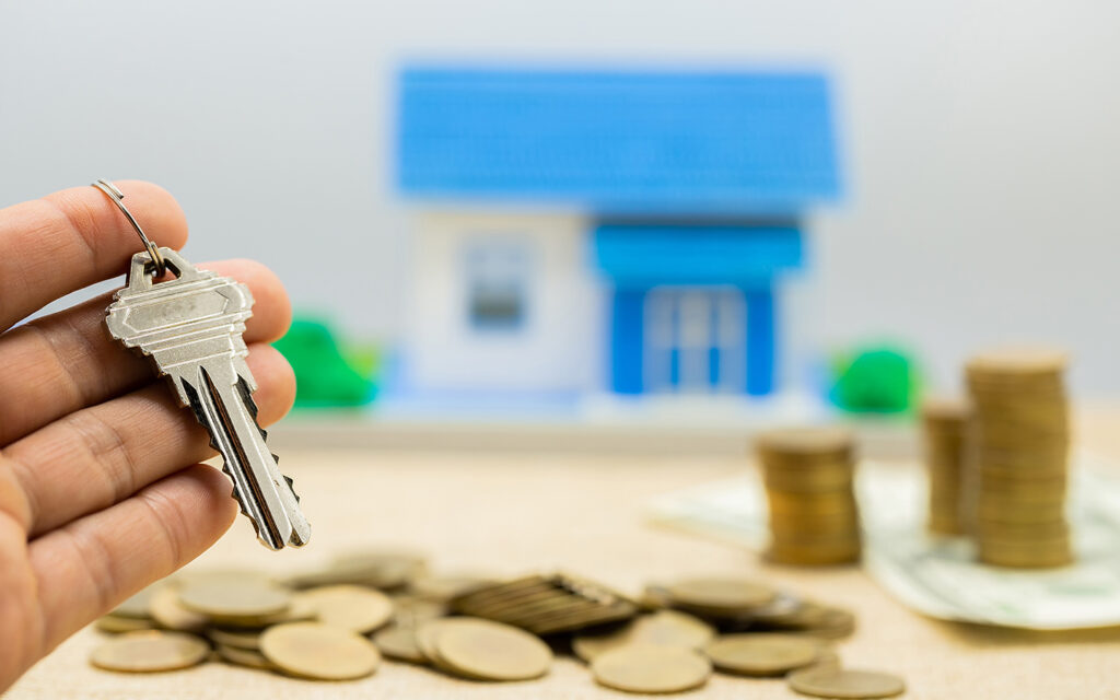 Schlüssel, Geldstapel und Häuser als Symbole für Hypothekendarlehen.