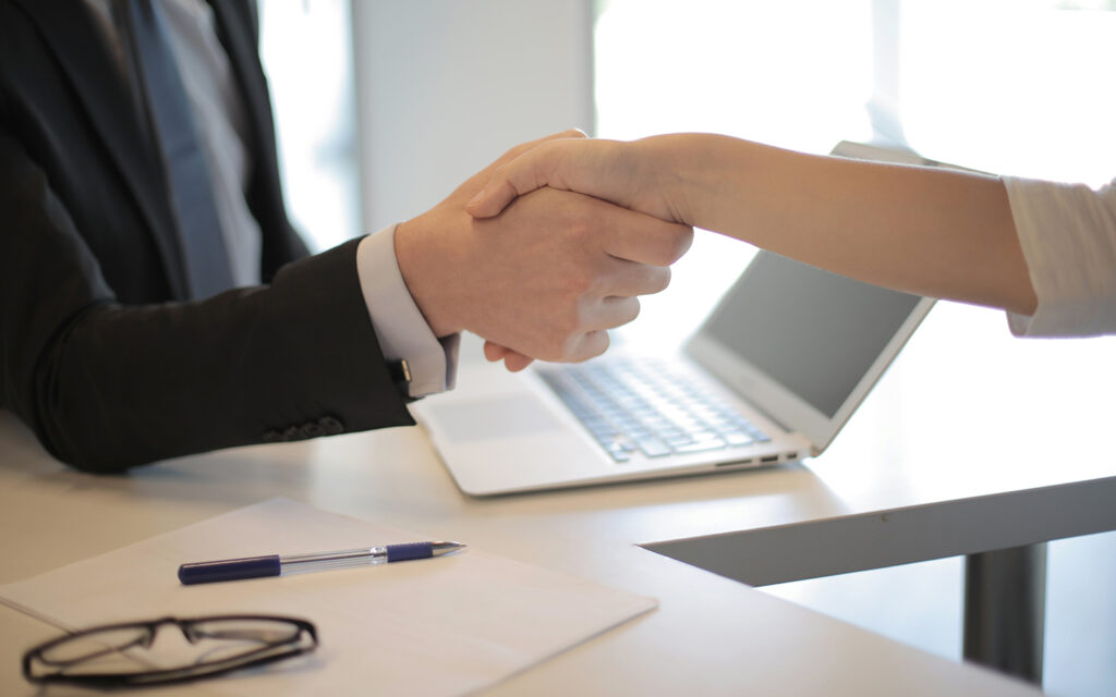 Arbeitgeber und Arbeitnehmerin geben sich die Hand