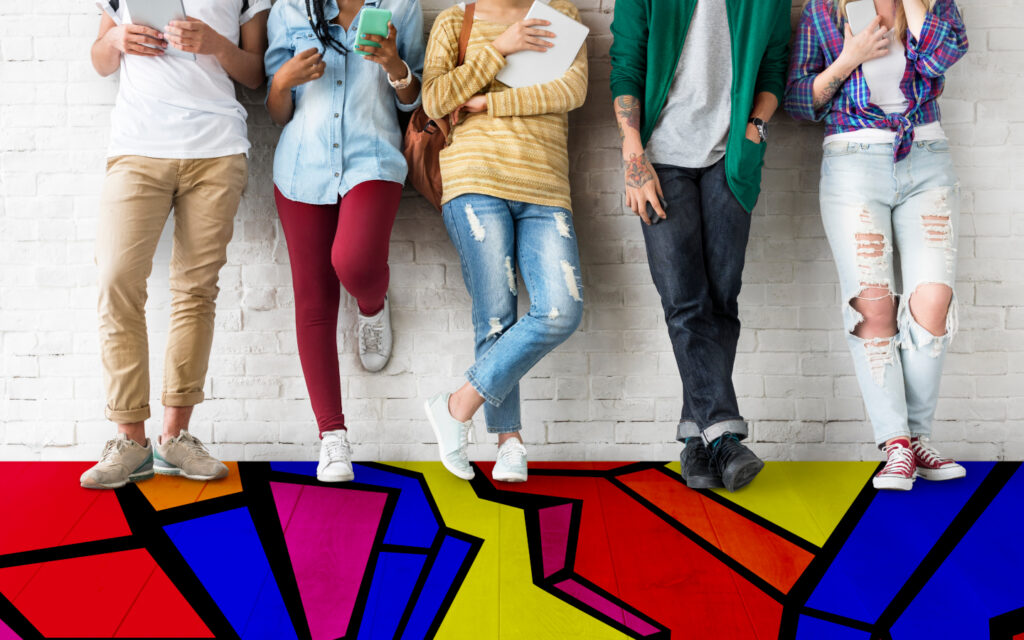 Eine Gruppe junger Menschen steht auf eine bunten Boden.