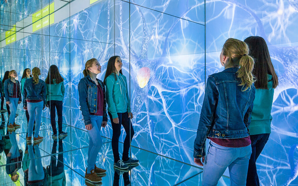 Jugendliche stehen in einem Spiegellabyrinth in der inatura